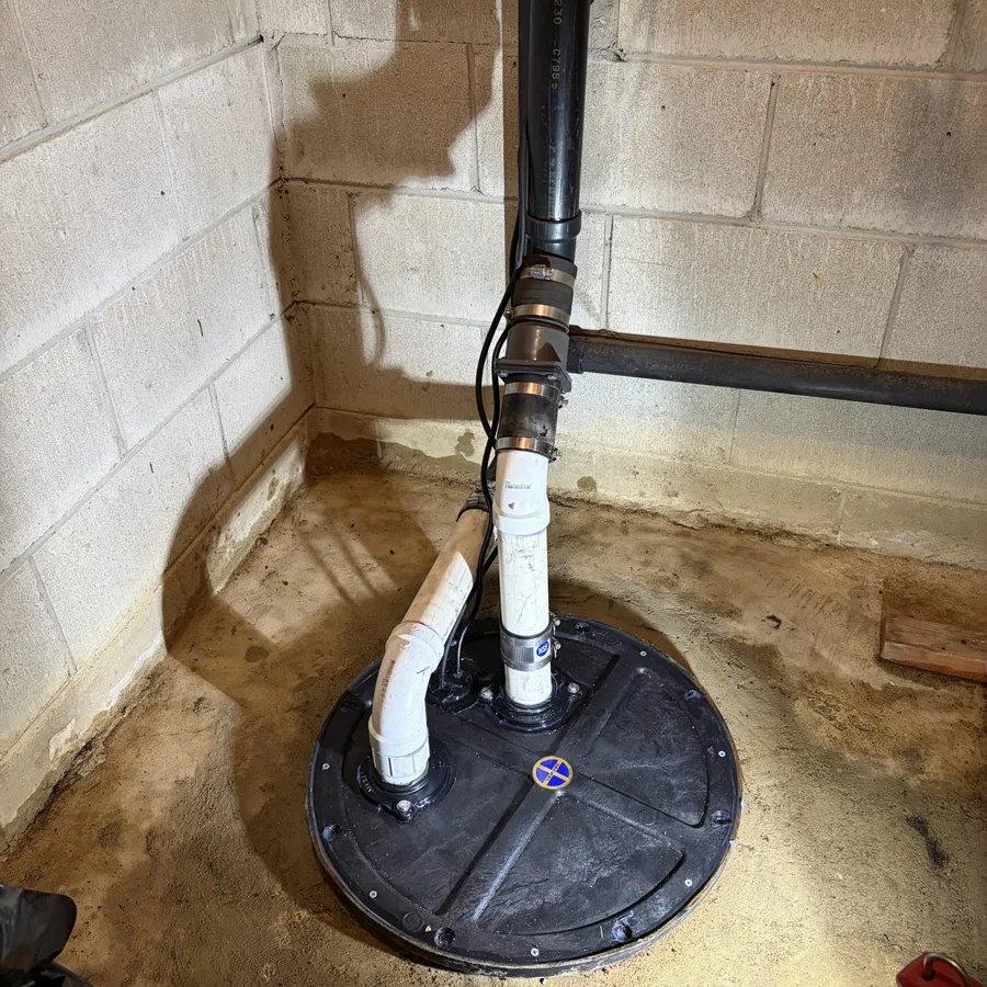 Sealed pump pit with PVC discharge piping in a basement