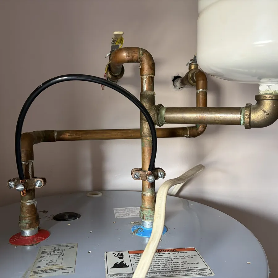 Copper and brass piping connected to the top of a water heater