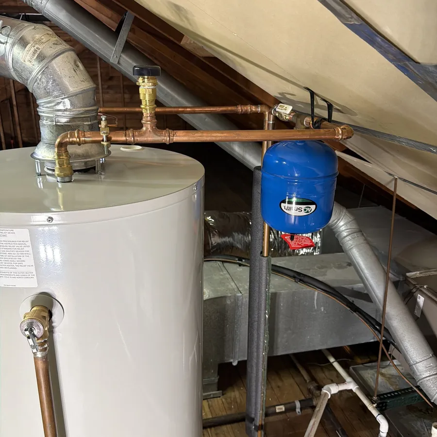 Water heater with a new expansion tank and copper piping installed in an attic